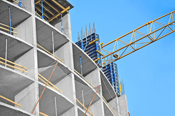 Fototapeta premium Crane and building construction site against blue sky