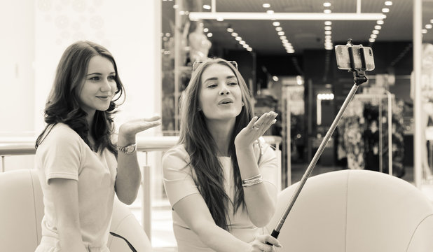 Girlfriends with smartphone in shopping mall. Instagram style