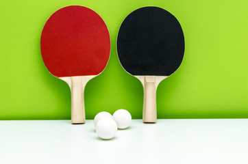 Pair of ping-pong rackets and white balls