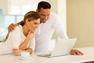 couple using laptop while having coffee