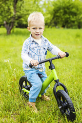 Fototapeta na wymiar Little boy riding learner bike in park 