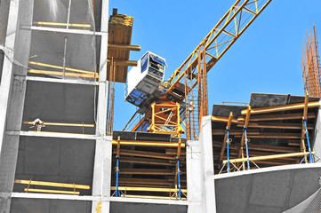 Crane and building construction site against blue sky