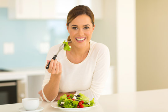 healthy young woman eating salad