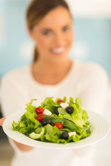 young woman presenting green salad