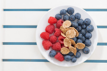 blueberries, raspberries and wholegrain flakes on a plate