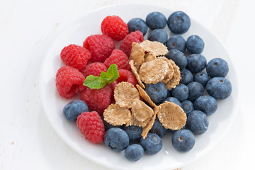 blueberries, raspberries and wholegrain flakes on white 