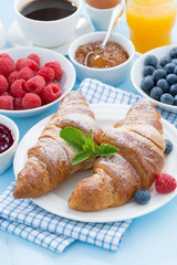 breakfast with croissants, fresh berries and orange juice
