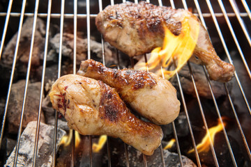 Grilled chicken thigh over flames on a barbecue