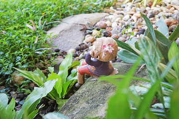 top view of clay girl doll decorated in garden