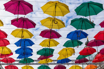 Fototapeta na wymiar Street decoration, lots of colorful umbrellas in the air