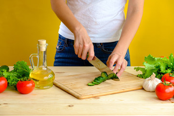 Woman cutting cucumber
