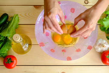 Woman breaking eggs into a bowl