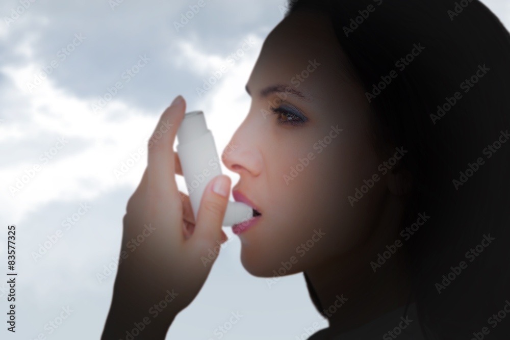 Poster Composite image of asthmatic brunette using her inhaler 