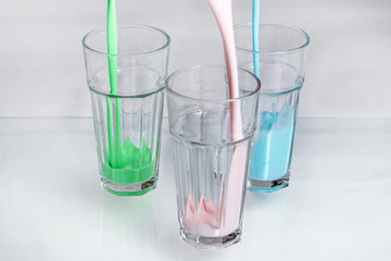 Three milk shake glasses pouring