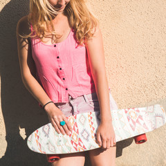 Blonde skateboarder woman posing outdoor