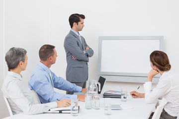 Business team looking at white screen