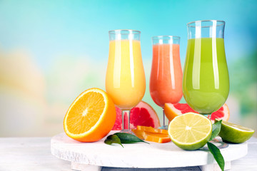 Fresh summer cocktails on wooden table on bright blurred background