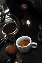 Porcelain white cup of coffee and portafilter of an espresso machine