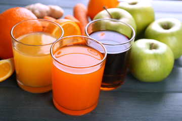 Assortment of healthy fresh juices and fruits on wooden table background