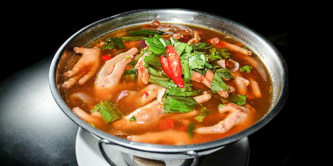 Spicy soup Chicken Foot in hot bowl and black background