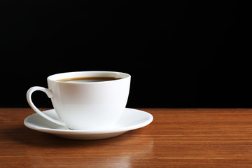 Cup of coffee on table on dark background