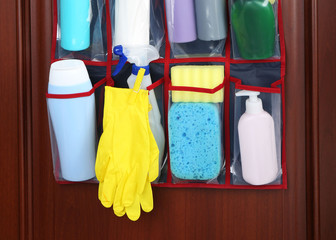 Different detergents in hanging bag wooden door