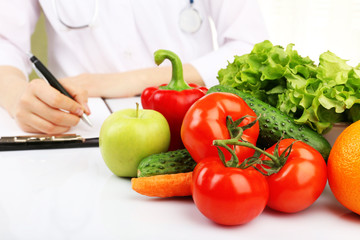 Nutritionist doctor writing  diet plan in office