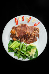 Roasted pork with vegetables in black background