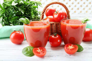 Glasses of fresh tomato juice on wooden table, closeup