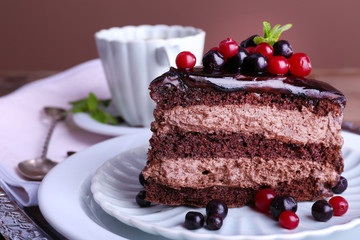 Delicious chocolate cake with berries on plate on table close up