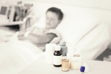 Obraz na płótnie Canvas Medicines on table with boy in bed