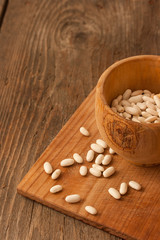 Fototapeta na wymiar Beans in a wood pot on natural textured wood background