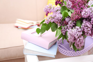 Beautiful lilac flowers in vase on table of interior background