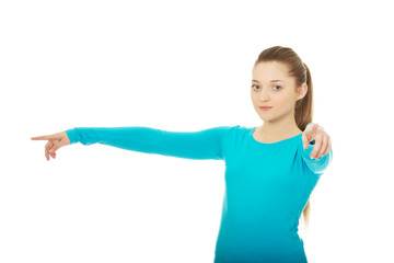 Young woman pointing on you and aside.