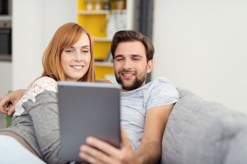 paar schaut zuhause auf tablet-pc