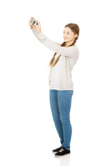 Teen woman making photo with camera.