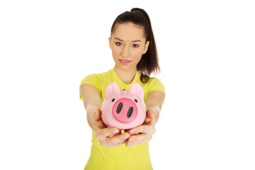 Happy woman holding piggybank.