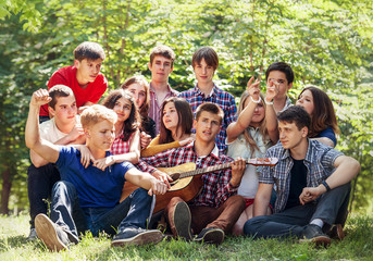 Groupe of happy young people singing with guitar together