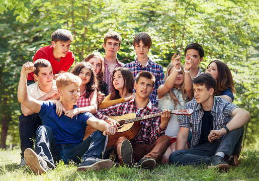 Groupe Of Happy Young People Singing With Guitar Together