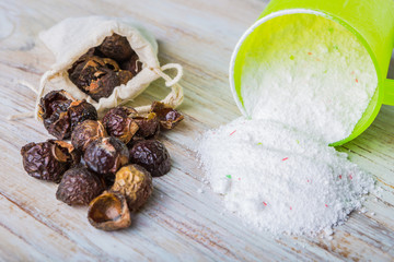 Natural soapnuts and washing powder on white table