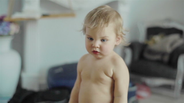 Close up of adorable cute little boy clapping hands and reacting with emotions standing in a room interior