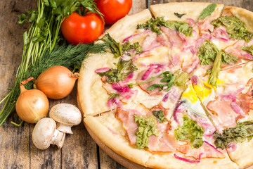 Gourmet pizza with ingredients around.