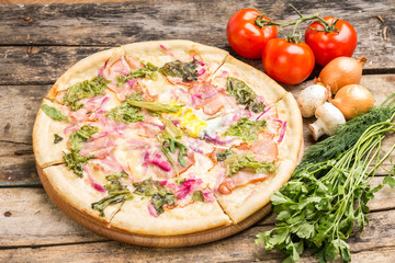 Gourmet pizza with ingredients around.