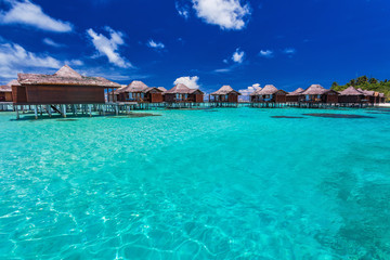 Luxurious overwater bungallows in the lagoon on a tropical islan