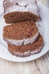 Tasty dark gingerbread cake on plate on wooden table