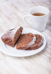Tasty dark gingerbread cake on plate on wooden table