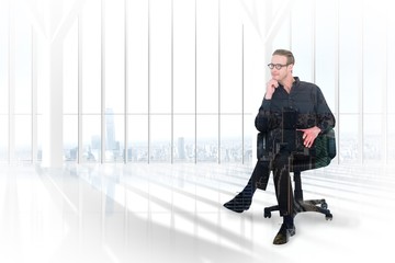 Thoughtful businessman sitting on a chair against city skyline