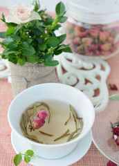 Cup of healthy green tea with dried roses