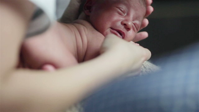 Close Up Of Tiny Newborn Baby Crying Desperately. Nurse In A Mask Trying To Calm Down Pitiful Tired Lying And Screaming Baby Boy  