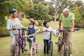 Obraz premium Happy grandparents with their grandchildren on their bike